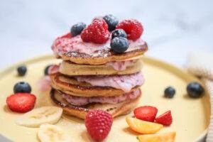 pancakes piled high with strawberries blueberries bananas Greek yogurt 